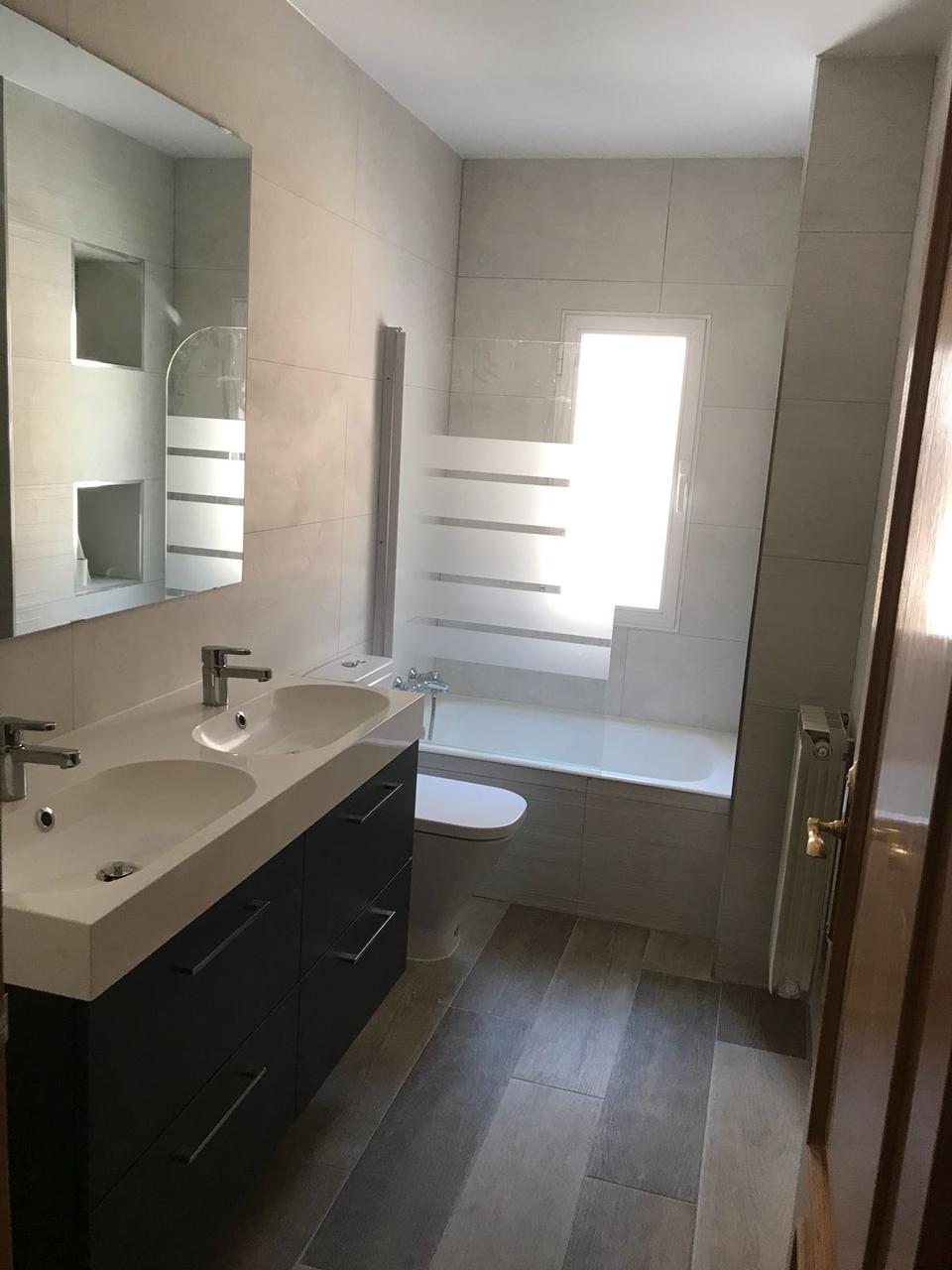 Baño con bañera y mueble de doble lavabo
