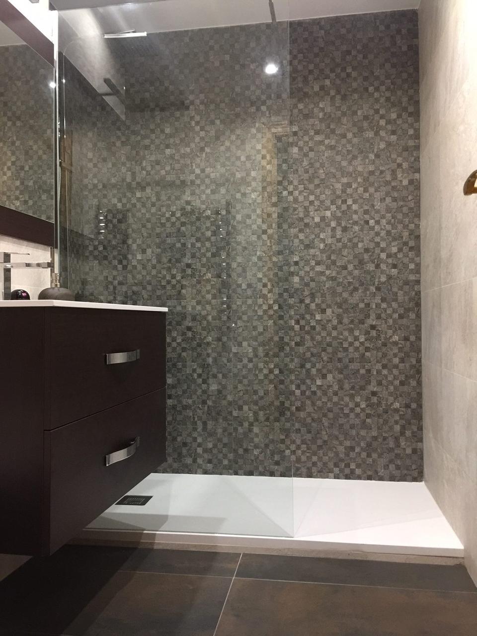 Ducha con mosaico en damero y panel fijo hasta el techo