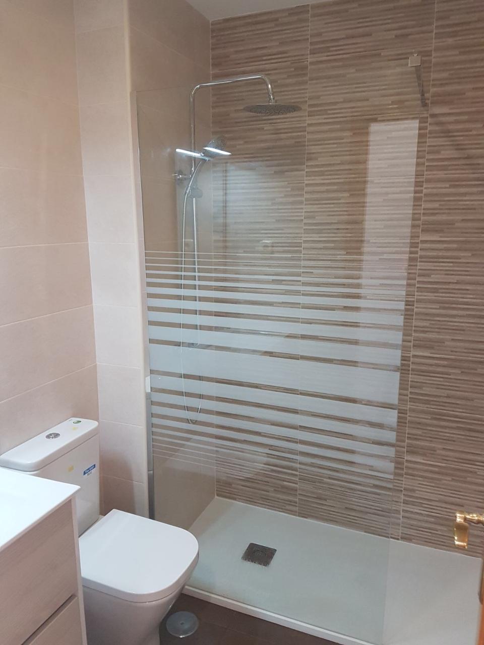 Ducha con panel de franjas al ácido y azulejo tono madera