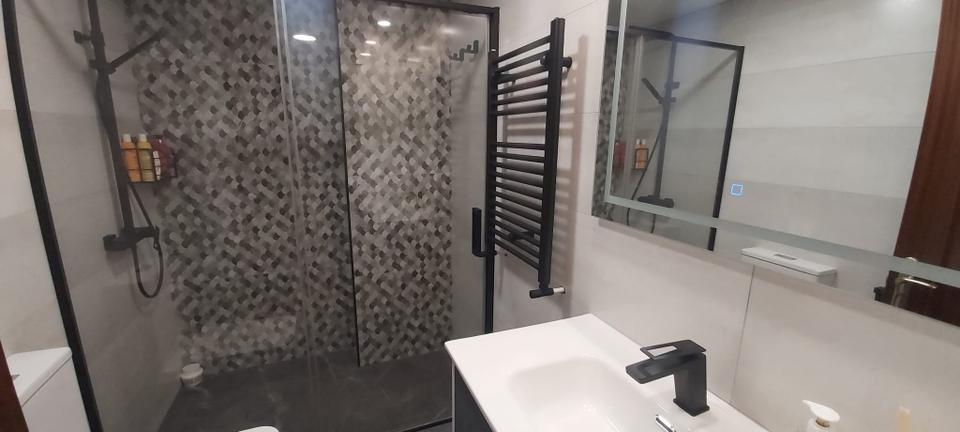 Baño con mosaico y grifería negra en Las Rozas