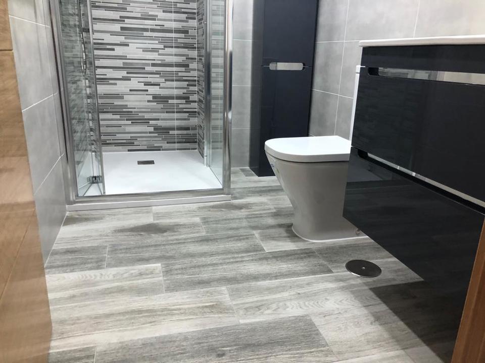 Baño con mosaico de tiras y mueble lacado oscuro