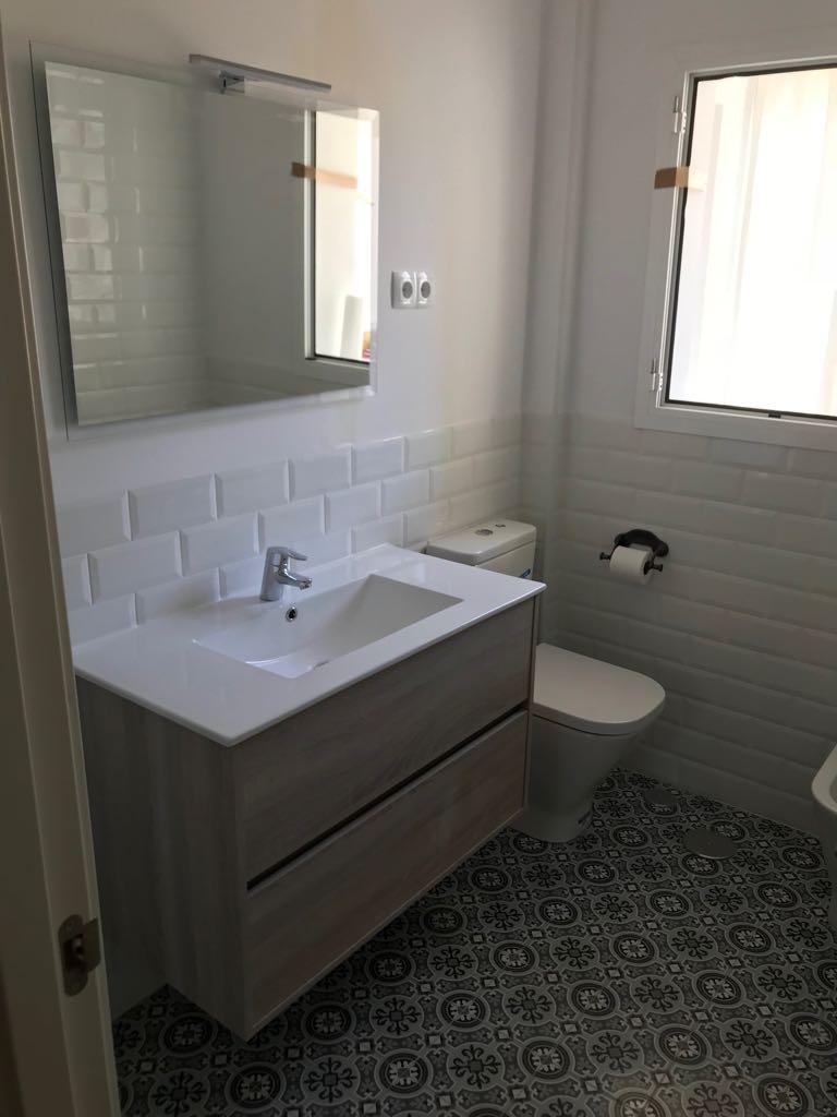 Baño con azulejo metro y suelo hidráulico en Leganés