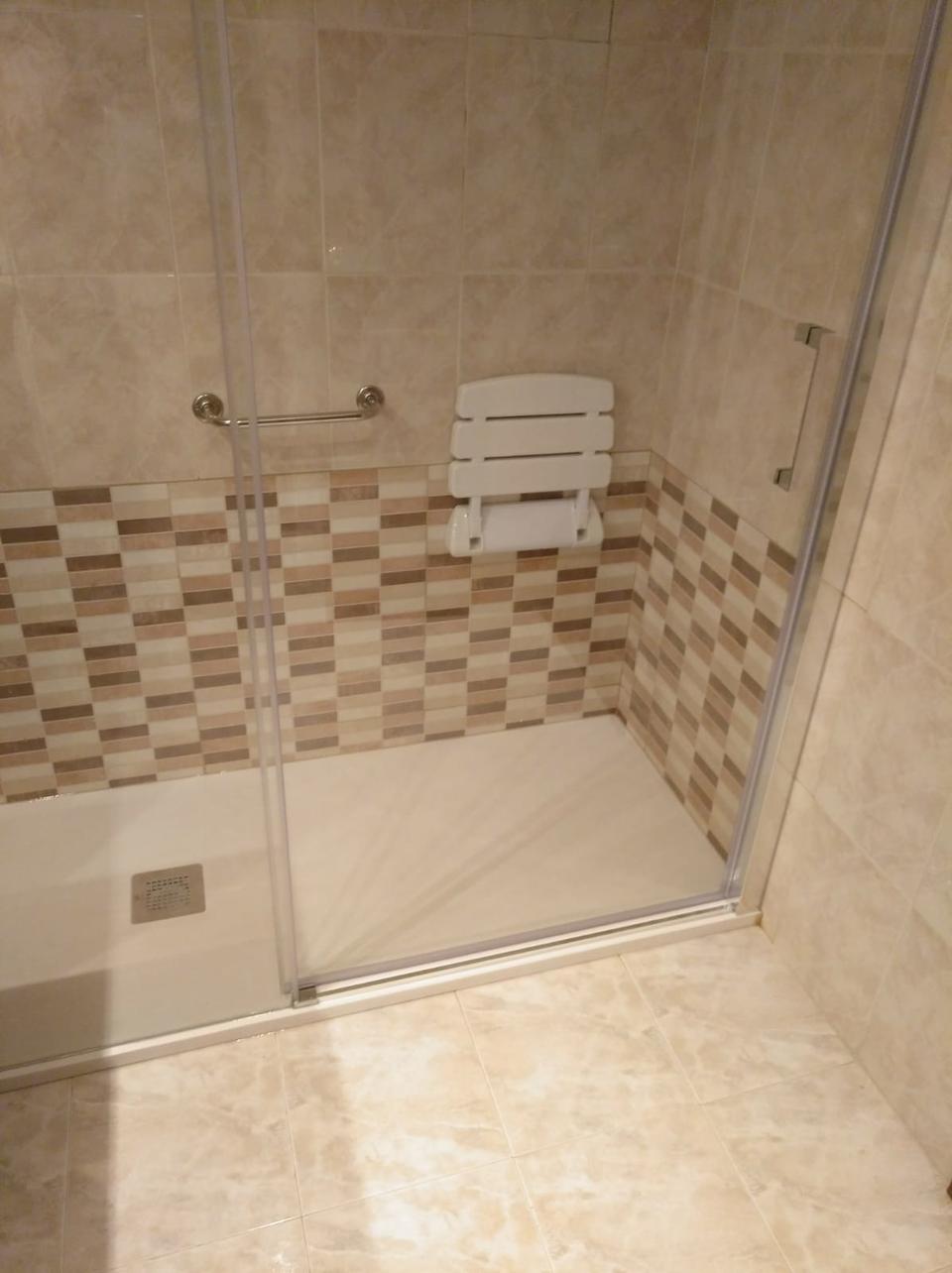 Ducha con asiento abatible y asideros