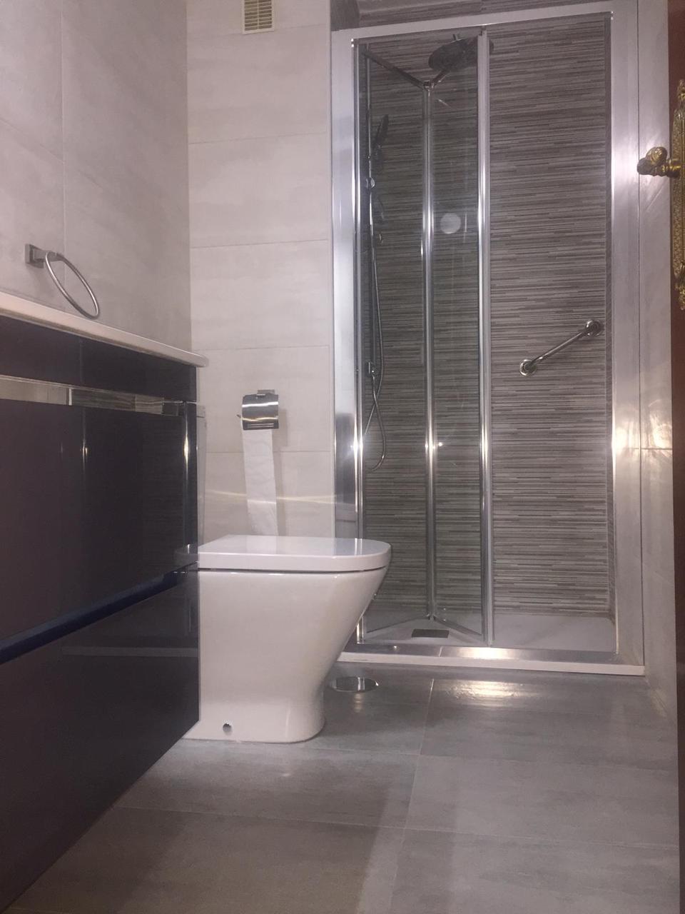 Ducha con mampara plegable y barra de apoyo